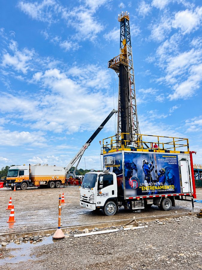 El Ecco Móvil estacionado junto a un taladro de perforación petrolera, con la plataforma superior armada bajo el cielo azul.