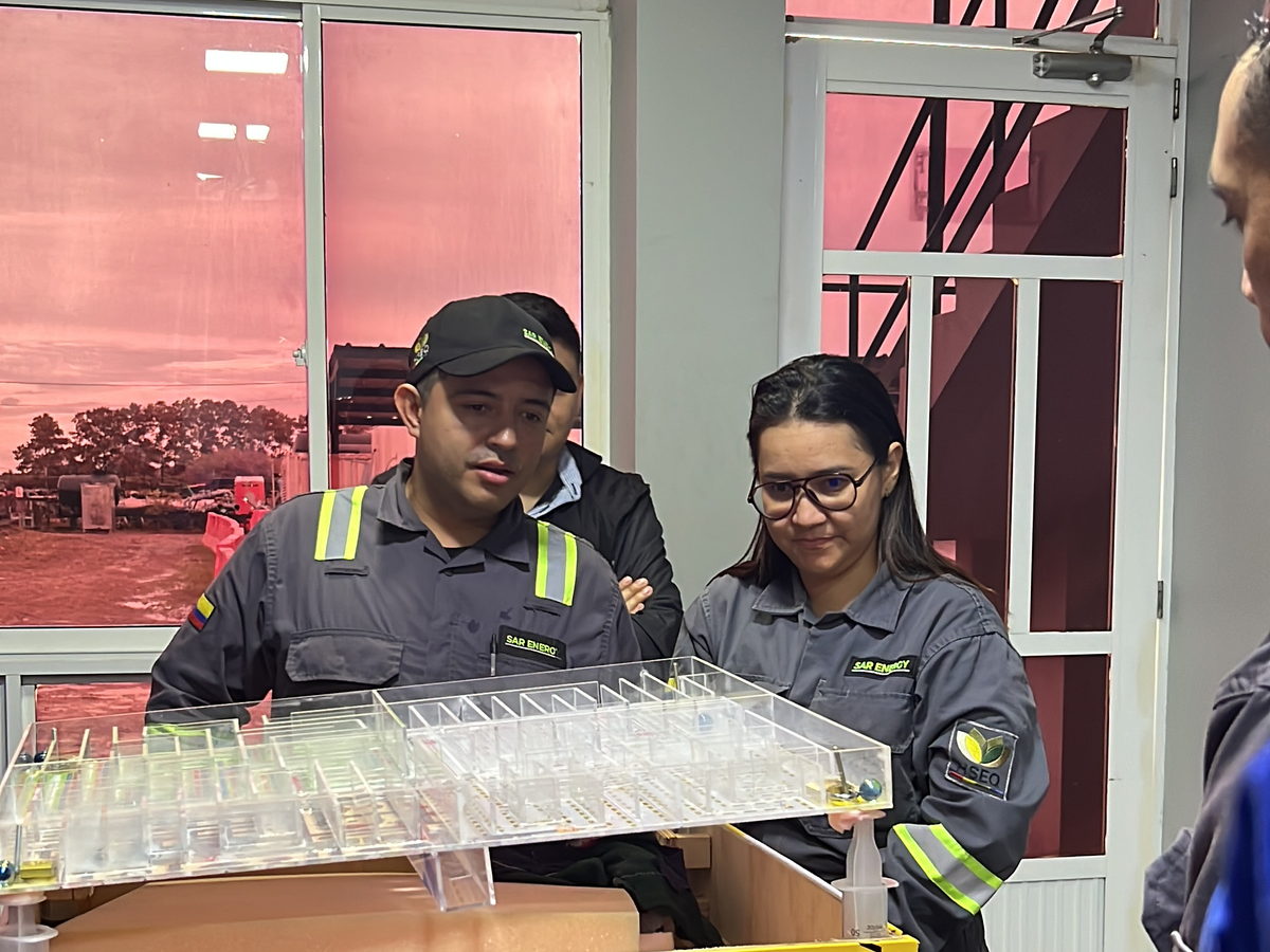 Dos participantes manipulando una maqueta didáctica de energías peligrosas durante una práctica de bloqueo.