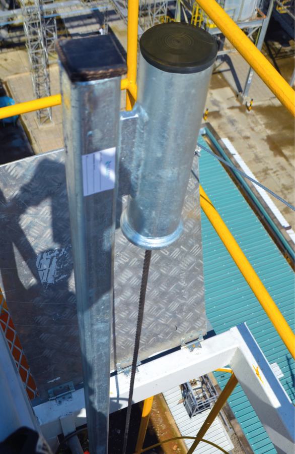 Mástil superior galvanizado instalado en lo alto de la escalera, con el cable de acero descendiendo.