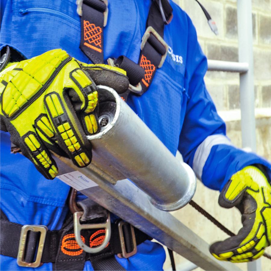 Técnico de Eccosis con guantes de impacto sostiene el mástil superior galvanizado de la línea de vida.